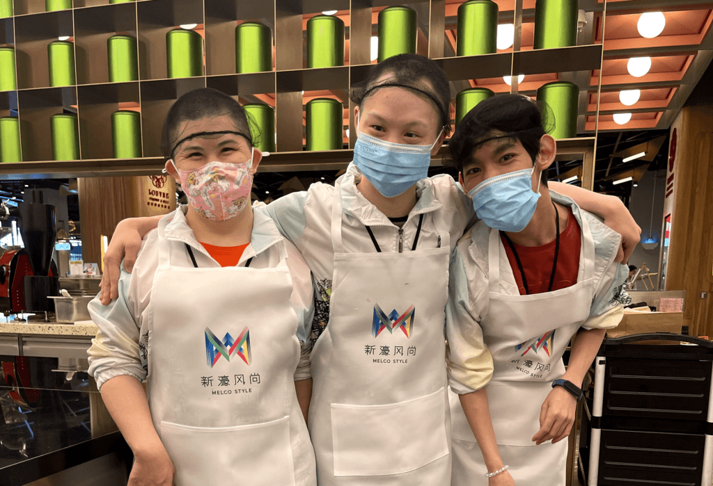 A chef in a kitchen teaching a class of students how to cook